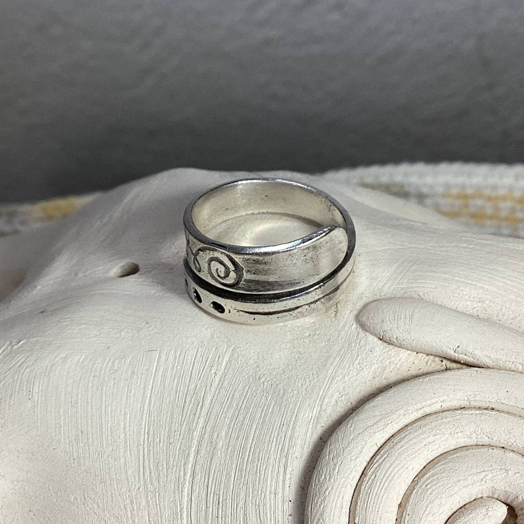 Anillo ajustable de plata de ley con símbolo Unalome grabado en el exterior representando el camino de conciencia y crecimiento personal